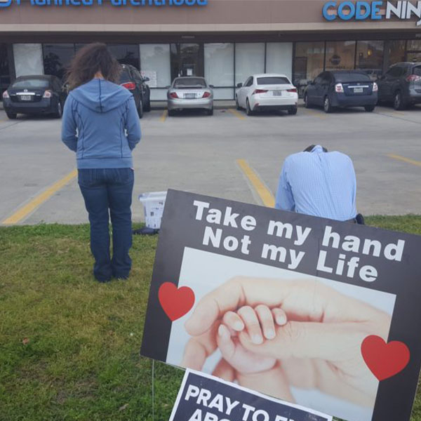 Volunteers praying at Planned Parenthood